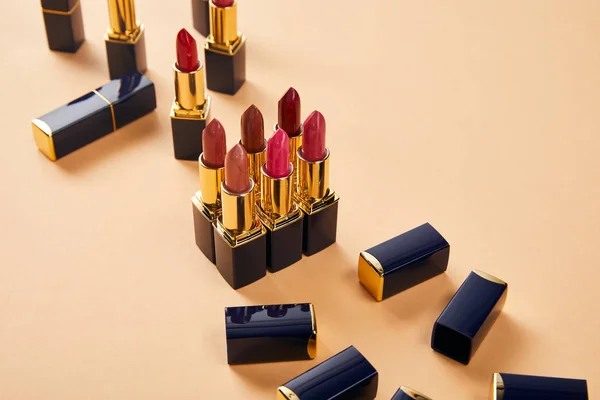 Diferentes tonos rojos de lápices labiales en beige - foto de stock