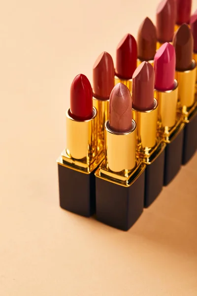 Closeup of shades of lipstick in tubes on beige — Stock Photo