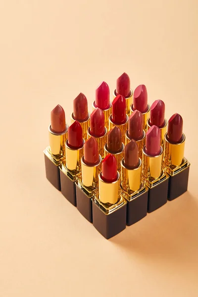 Primer plano de varios lápices labiales en beige - foto de stock