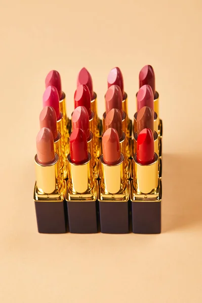 Gros plan de différents rouges à lèvres sur beige — Photo de stock