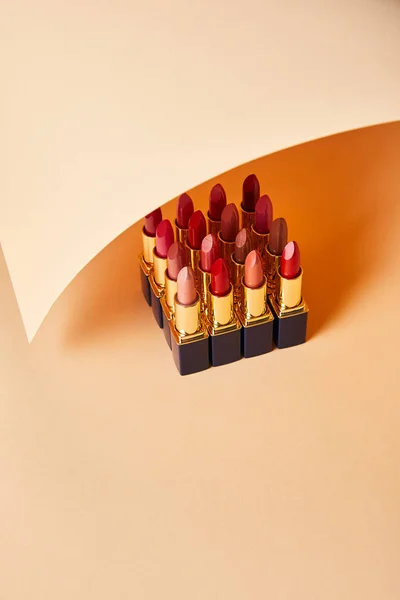 Various red shades of lipsticks on beige — Stock Photo