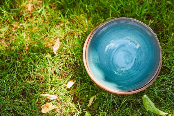 Top view of blue ceramic bowl on green grass — Stock Photo