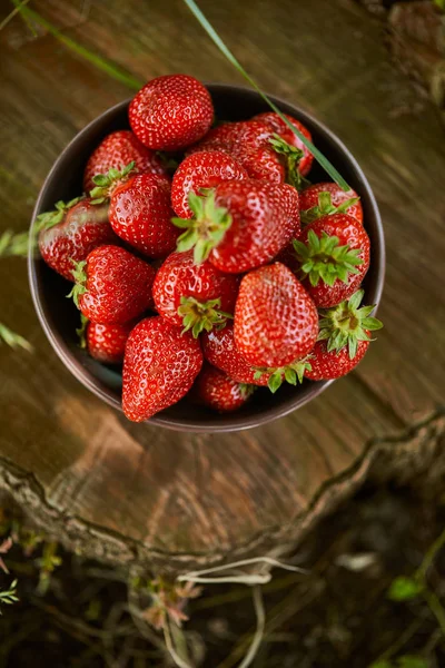 Vue du dessus des fraises rouges fraîches dans un bol sur moignon — Photo de stock