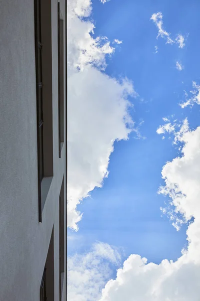Vista inferior del edificio y el cielo azul con nubes - foto de stock