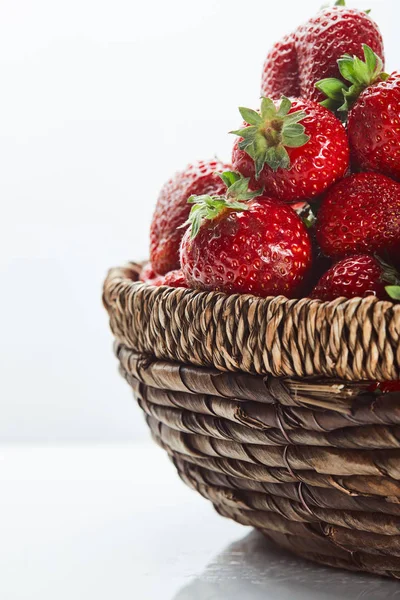 Fresh red strawberries in wicker basket on white — Stock Photo