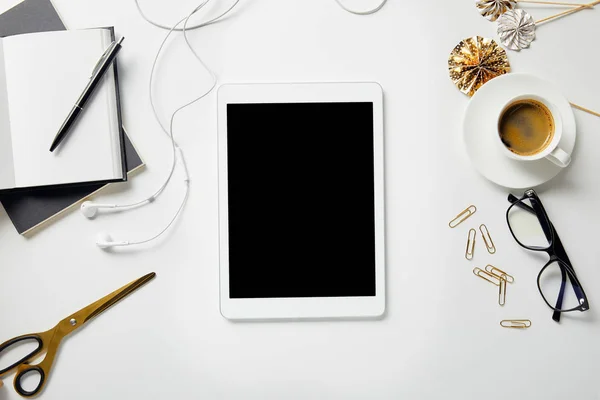 Draufsicht auf digitales Tablet, Schreibwaren, Schere, Kaffee, Brille, Kopfhörer und Notizbücher mit Stift auf weißer Oberfläche — Stockfoto