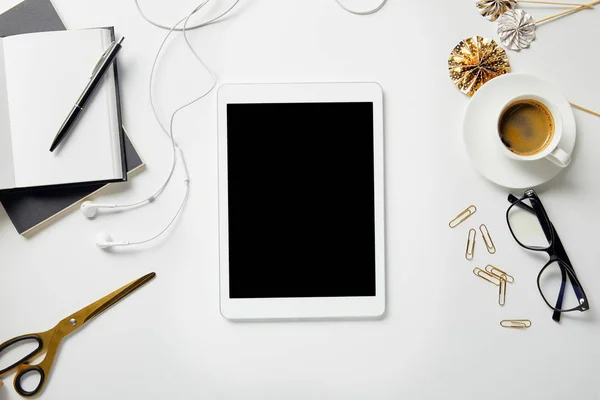 Vue de dessus de tablette numérique, papeterie, ciseaux, café, lunettes, écouteurs et ordinateurs portables avec stylo sur la surface blanche — Photo de stock