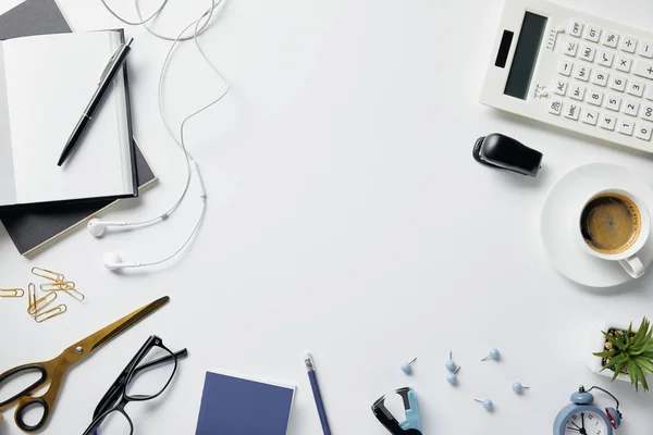 Vista superior da planta, copos, café, fones de ouvido e material de escritório na superfície branca — Fotografia de Stock