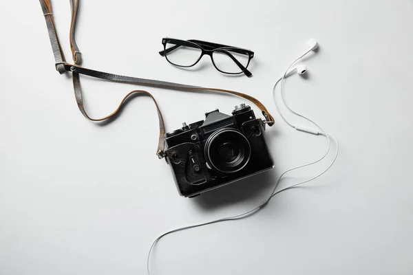 Vista superior de auriculares, gafas y cámara de fotos en la superficie blanca - foto de stock