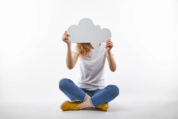 Woman with thought bubble in hands sitting isolated on white — Stock Photo