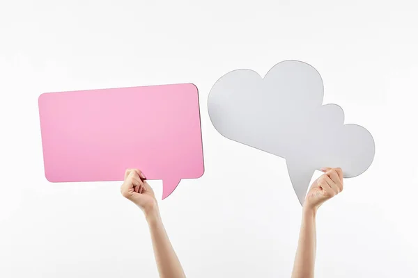 Cropped view of woman with pink thought and speech bubbles in hands isolated on white — Stock Photo