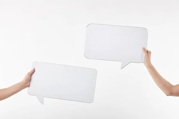 Cropped view of two women with speech bubbles in hands isolated on white — Stock Photo