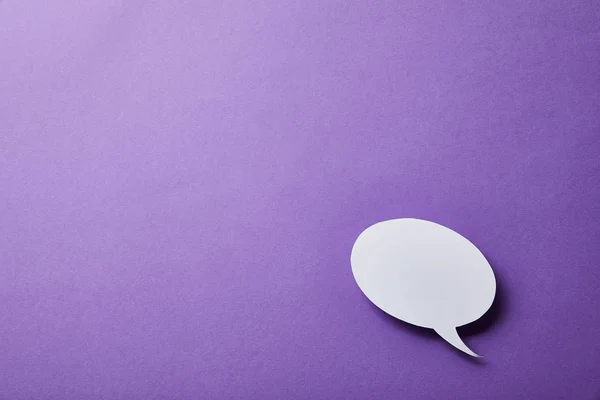 White speech bubble card on purple surface — Stock Photo