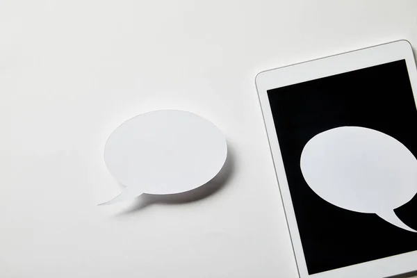 Smartphone with speech bubbles on white surface — Stock Photo