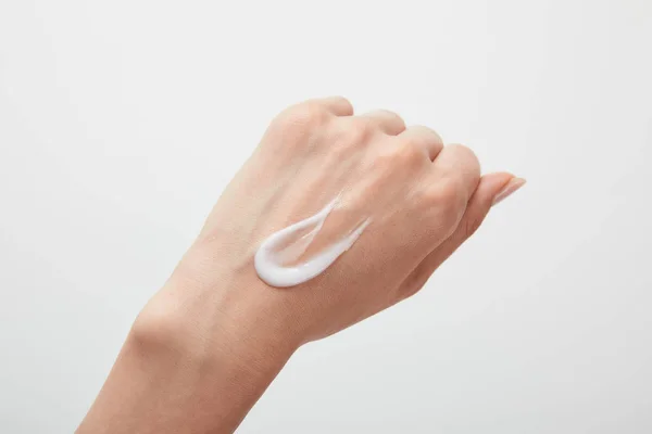 Abgeschnittene Ansicht der Frau Hand mit Creme auf der Haut isoliert auf weiß — Stockfoto