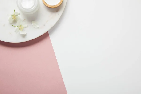 Top view of plate with cream and flowers on white pink surface — Stock Photo