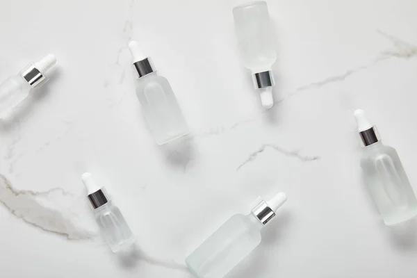 Top view of cosmetic glass bottles on white surface — Stock Photo