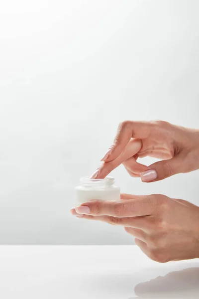 Vue recadrée de la femme tenant le pot avec de la crème dans les mains — Stock Photo