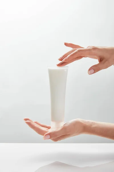 Visão recortada de mulher segurando tubo de creme cosmético em mãos — Fotografia de Stock