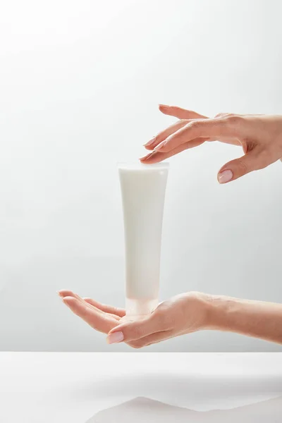 Cropped view of woman holding cosmetic cream tube in hands — Stock Photo