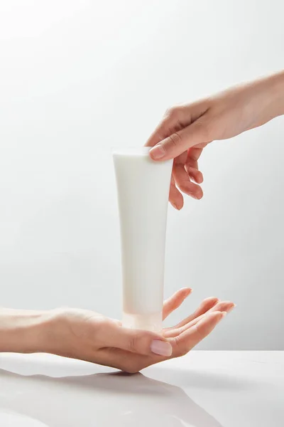 Vue recadrée des mains de la femme tenant la crème cosmétique dans le tube — Photo de stock