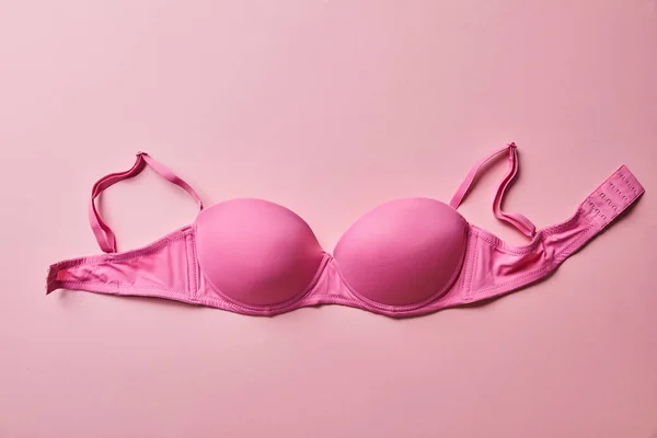 Вид зверху рожевого бюстгальтера на світло-рожевому фоні, концепція раку молочної залози — стокове фото