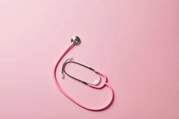 Top view of pink stethoscope on light pink background — Stock Photo