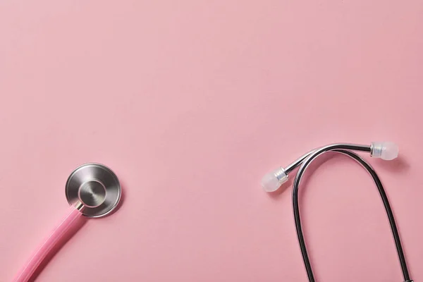 Top view of pink metal stethoscope on light pink background — Stock Photo