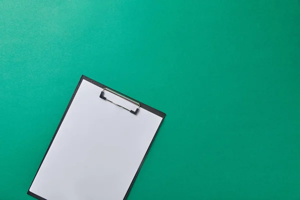 Top view of folder with empty paper isolated on green — Stock Photo