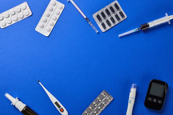 Draufsicht auf verschiedene medizinische Hilfsmittel auf blauem Hintergrund — Stockfoto
