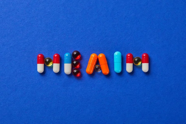 Vista superior da saúde palavra feita a partir de várias pílulas no fundo azul — Fotografia de Stock