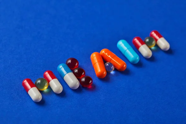 Word health made from various pills on blue background — Stock Photo