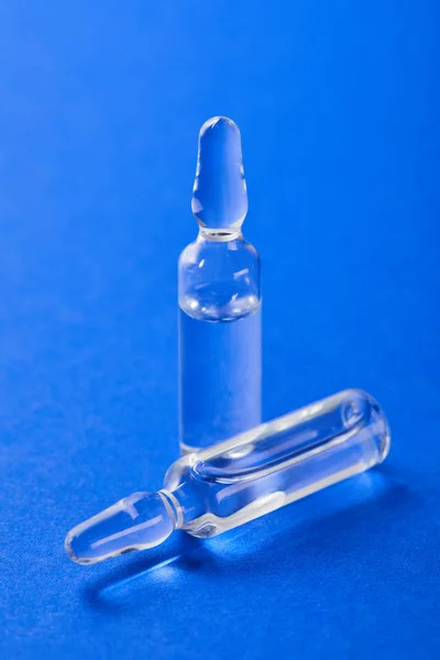Vista de cerca de dos ampollas en la superficie azul - foto de stock
