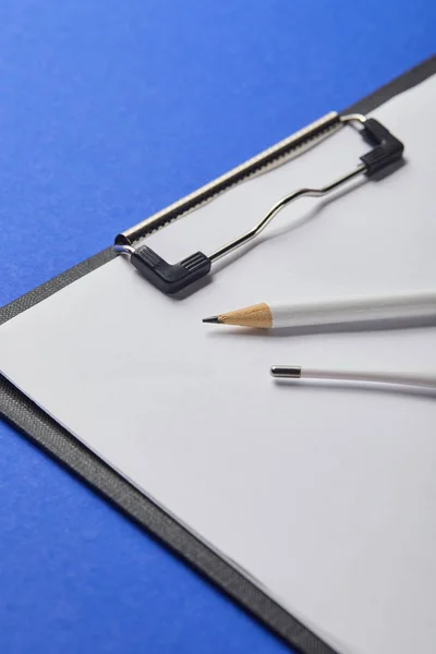Nahaufnahme von Bleistift und Thermometer auf Klemmbrett isoliert auf blau — Stockfoto