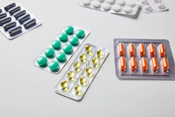 Plaquettes thermoformées dispersées avec différentes pilules isolées en blanc — Photo de stock
