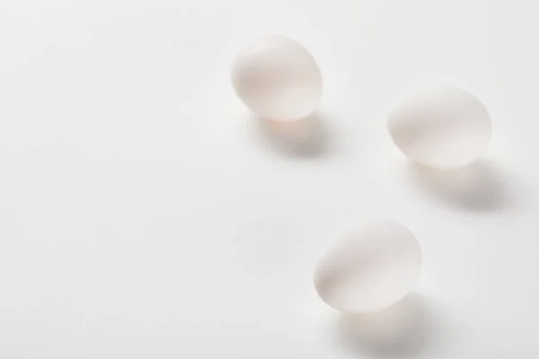 Chicken eggs on white surface with copy space — Stock Photo