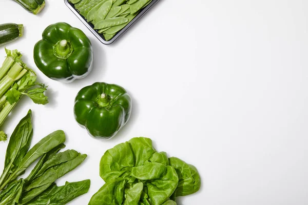 Top view of green nutritious vegetables on white background with copy space — Stock Photo