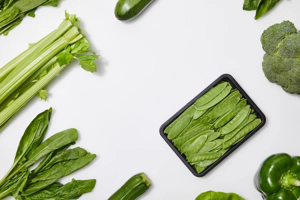 Top view of green nutritious vegetables on white background with copy space — Stock Photo