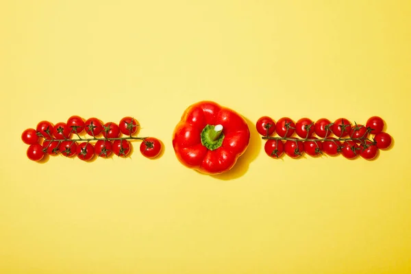 Tendido plano con tomates rojos cereza y pimentón sobre fondo amarillo - foto de stock