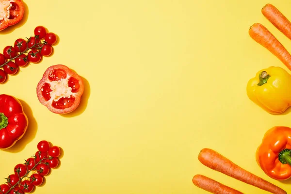 Vista superior de las verduras rojas y anaranjadas sobre fondo amarillo - foto de stock