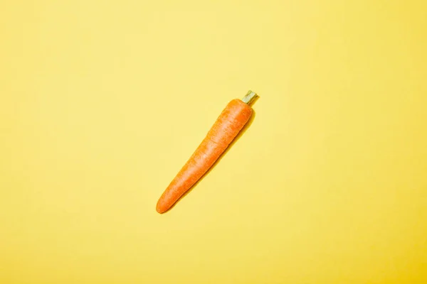 Vue du dessus de la carotte biologique sur fond jaune — Photo de stock