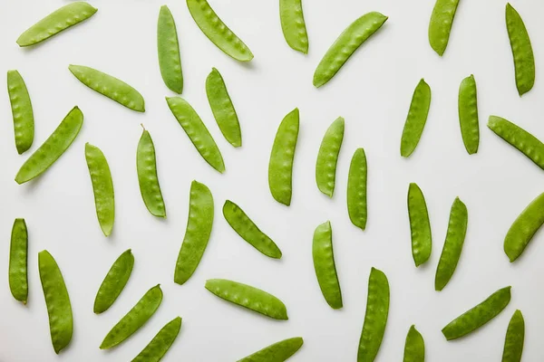 Top view of green peas scattered on white background — Stock Photo