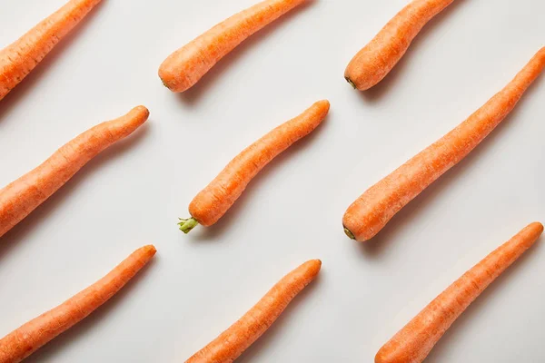 Acostado plano con zanahorias frescas sobre fondo blanco - foto de stock