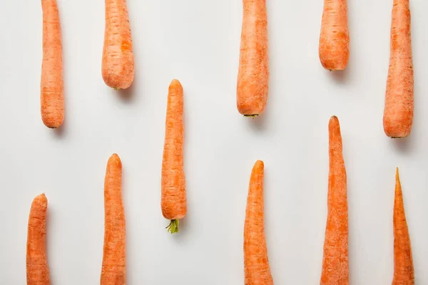 Acostado plano con zanahorias frescas sobre fondo blanco - foto de stock