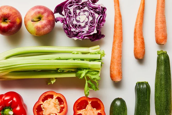 Flat lay with fresh carrots, leek, apples, bell pepper and zucchini on white background — Stock Photo