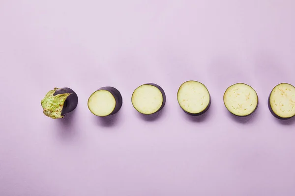 Top view of ripe sliced eggplant on violet background with copy space — Stock Photo