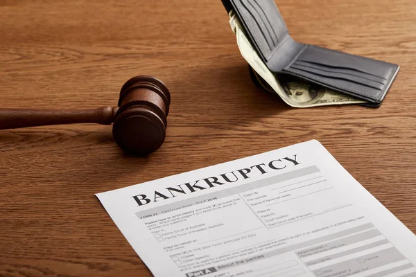 Bankruptcy form with wooden gavel, dollar banknote and wallet on brown wooden table — Stock Photo