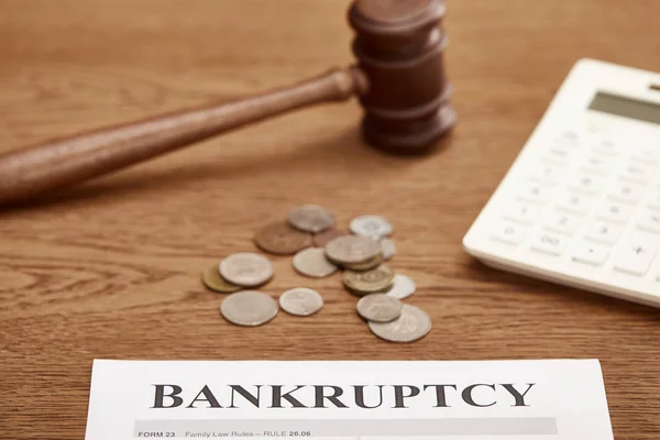 Selective focus of bankruptcy form, gavel, calculator and coins on brown wooden table — Stock Photo