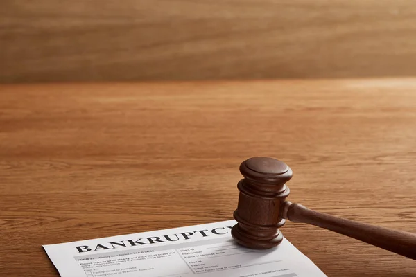 Bankruptcy form under judicial gavel on brown wooden table — Stock Photo