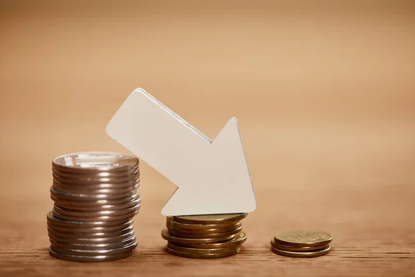 Decreasing chart made of coins with white arrow, bankruptcy concept — Stock Photo